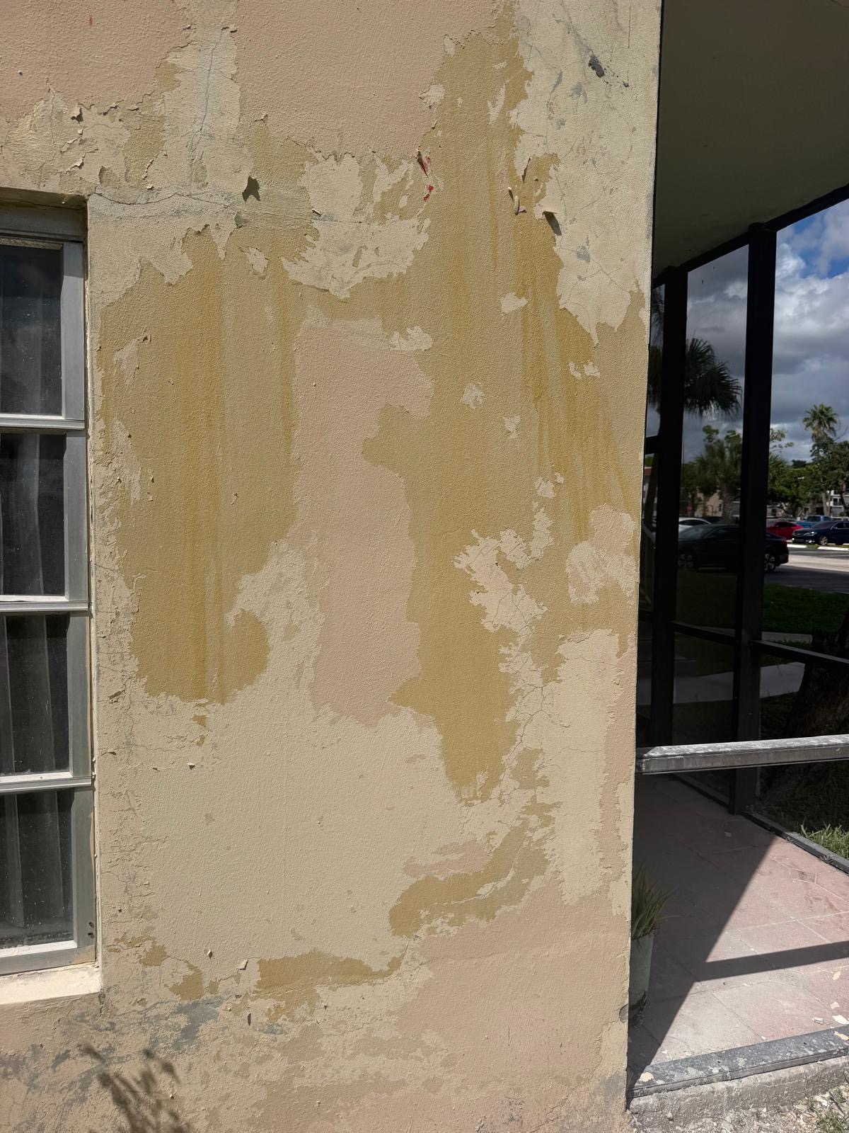 Close-up of existing stucco and coating conditions being prepared for exterior restoration